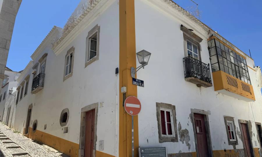 The corner house at Rua Gonçalo Velho and Calçada da Galeria: doors at street level and a balcony window with a stone surround on the floor above. Own photo — Flemming Berthelsen, 2026.
