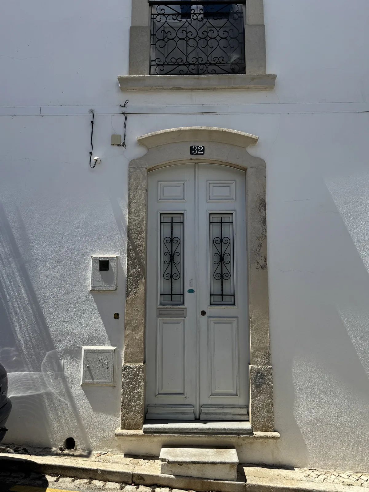 A stone portal with a segmental arch — possibly Gothic — set into the white corner house by Rua dos Mouros. Own photo — Flemming Berthelsen, 2026.