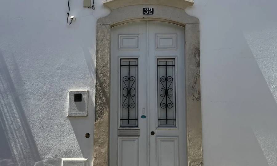 A stone portal with a segmental arch — possibly Gothic — set into the white corner house by Rua dos Mouros. Own photo — Flemming Berthelsen, 2026.