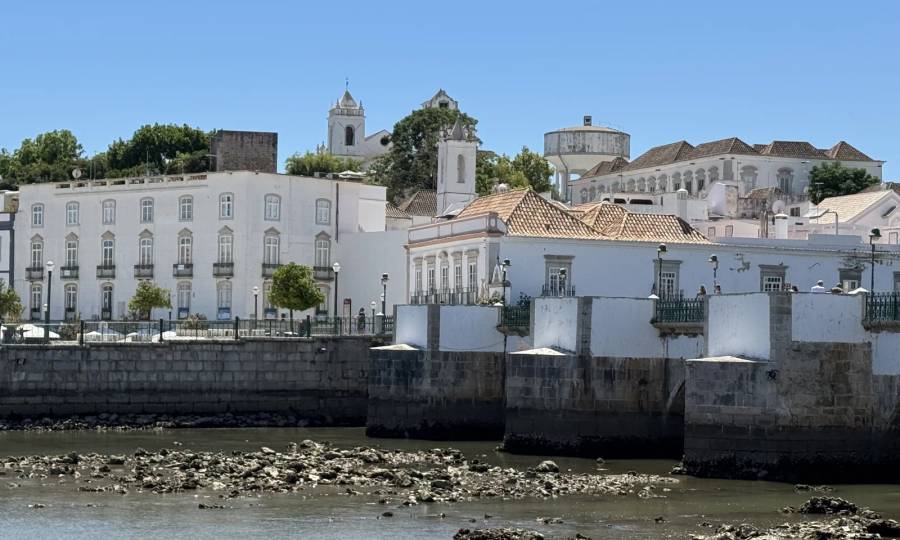 View from the other bank across the Gilão towards Tavira's white houses, the piers of the old bridge and the church towers on the hill. Own photo — Flemming Berthelsen, 2026.